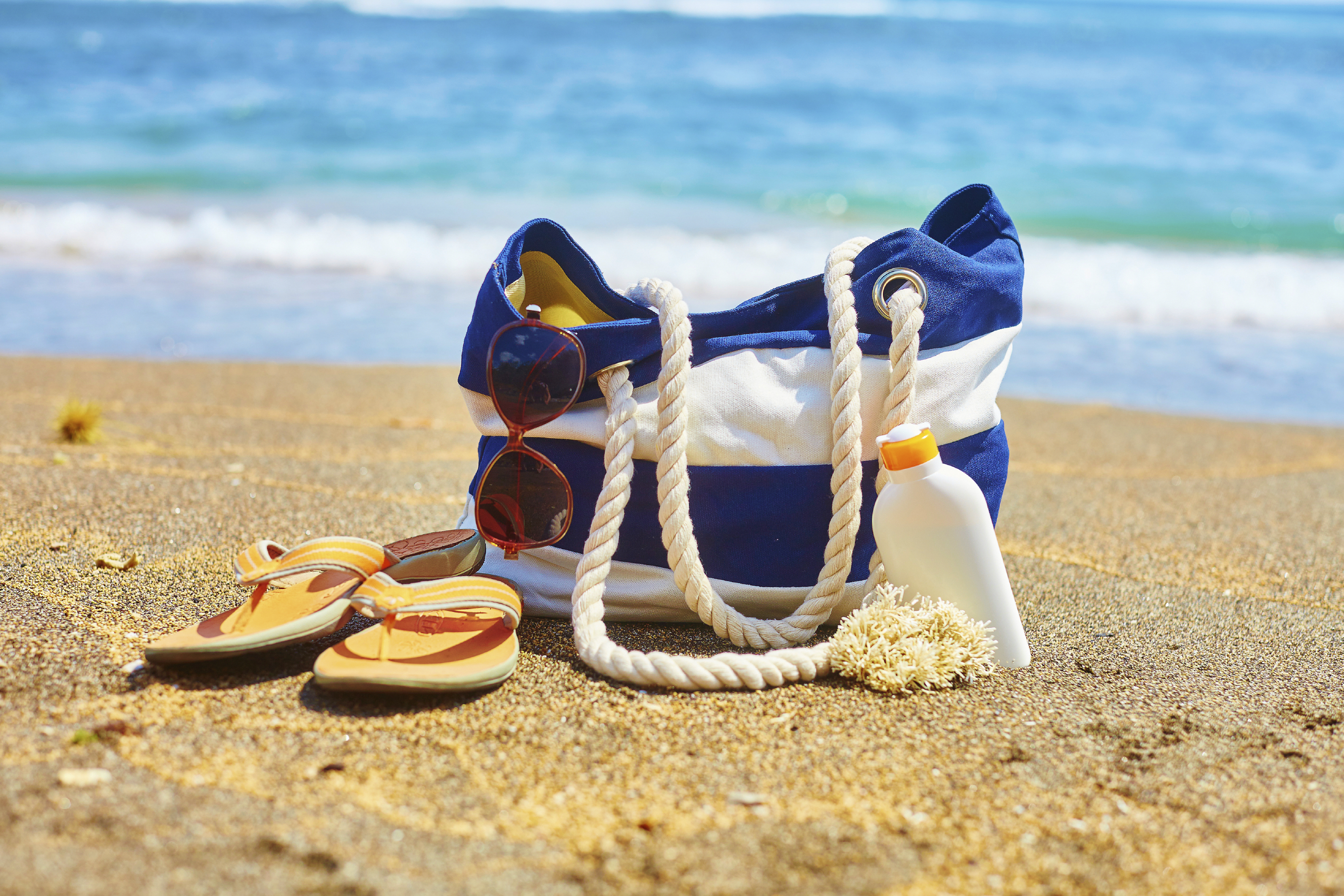 Beach bag, flip flops, and sunscreen bottle